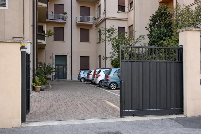Il cortile di un condominio con il cancello carraio.